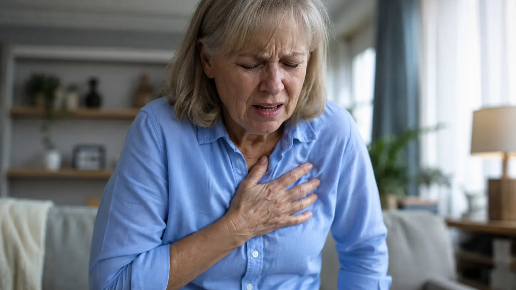 Older woman experiencing severe chest pain, a possible warning sign of a heart attack